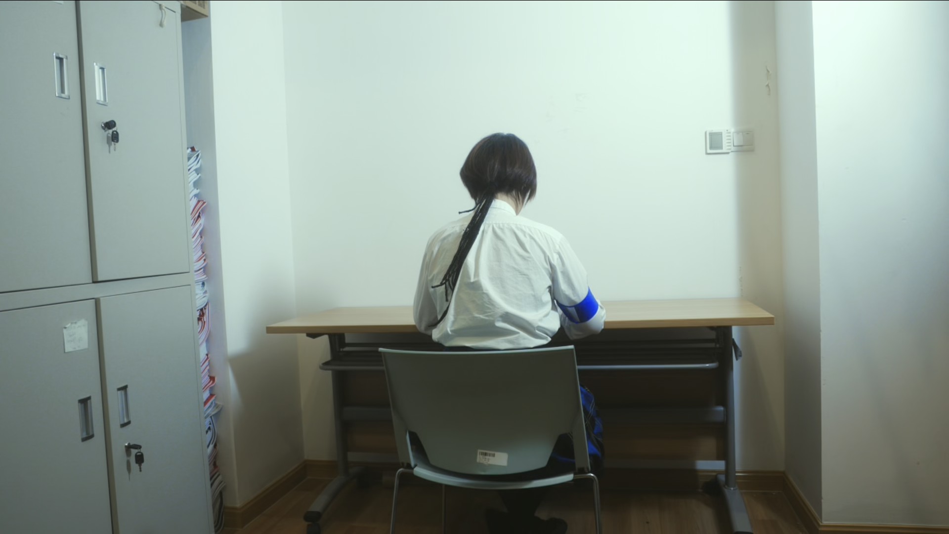Student seated at a desk wearing a blue armband
