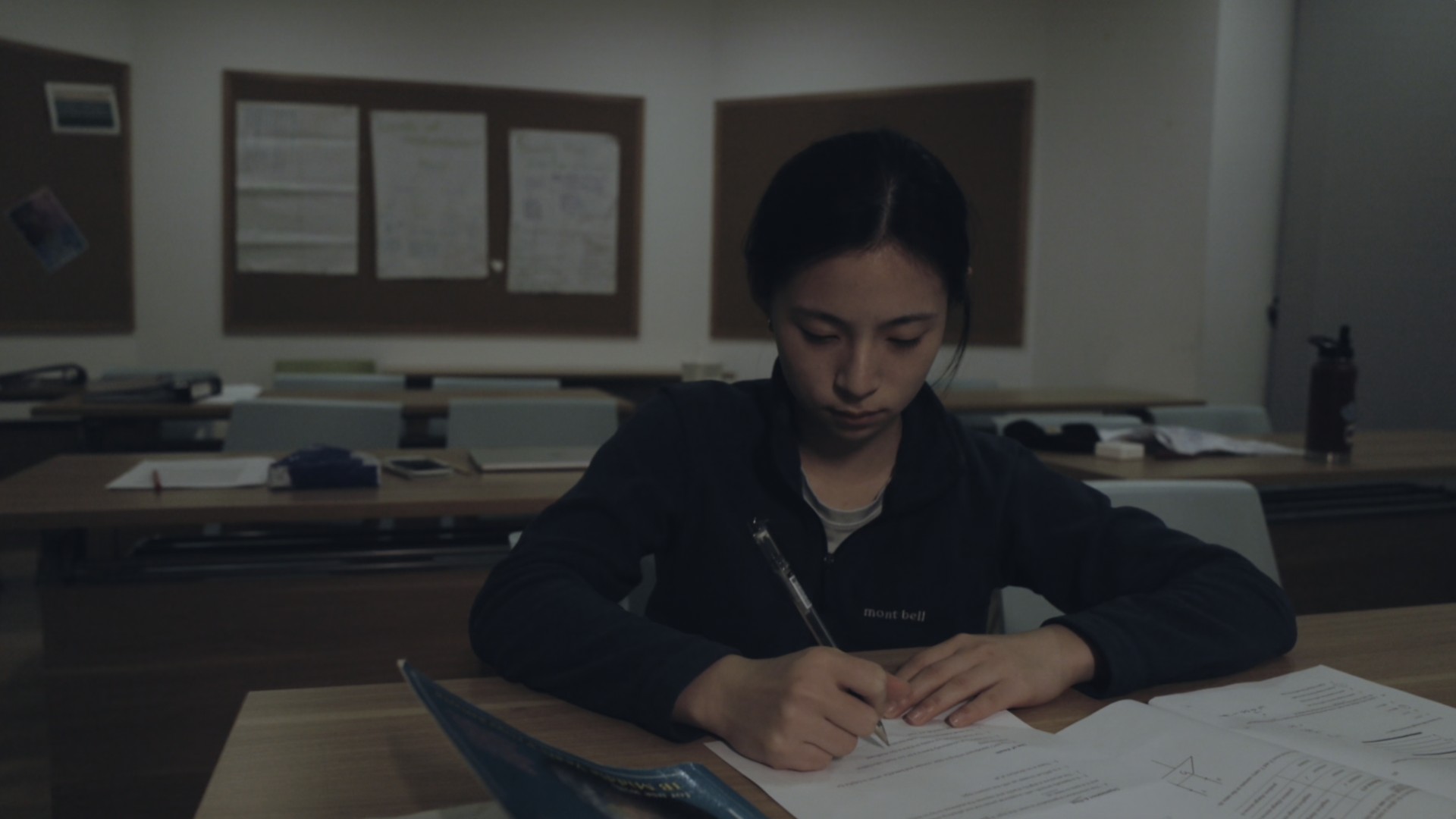 Ally writing at a classroom desk